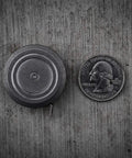 Ultra Tiny Titanium Ti Tape Retractable Mini Tape Measure With 3 Feet Range next to a quarter on concrete surface