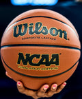 Hand holding NCAA Final Four Edition Basketball Official Size 29.5 Inch With High Definition Pebble Grip Deep Channel Construction