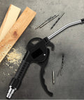Heavy Duty 4 Piece Air Blow Gun Kit With Angled Aluminum Nozzles And Slick Pistol Grip To Blast Off Dust And Chips Fast For Auto Detailing Crew Or Local Shop on a workbench with wood and tools.