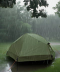 Camping Cot Tent Combo For Solo Adventures Waterproof Off Ground Bed For Adults 1 Person in rain on grassy field