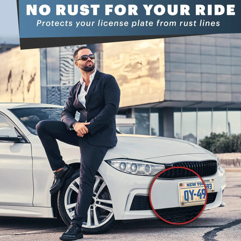 Man standing beside a car with a highlighted license plate showing effective protection from rust, urban background.