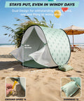Pop Up Baby Beach Tent With UPF 50+ Sun Shade Mosquito Net Shelter Portable Outdoor Canopy For Babies And Toddlers Green Leaves Pattern on sandy beach.