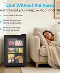 3.0 Cu Ft Upright Freezer With Clear Glass Door Sleek Black Cabinet next to a sleeping woman on a couch in a cozy setting.