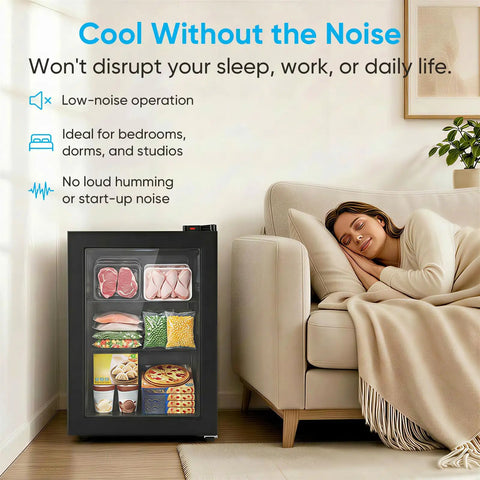 3.0 Cu Ft Upright Freezer With Clear Glass Door Sleek Black Cabinet next to a sleeping woman on a couch in a cozy setting.