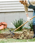Person using Heavy Duty Steel Garden Fork for soil loosening and deep soil turning in a garden, durable four-tooth design