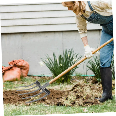 Person using Heavy Duty Steel Garden Fork for soil loosening and deep soil turning in a garden, durable four-tooth design