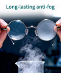Eyeglasses with round metal frames held over a steaming beaker, illustrating anti-fog.
