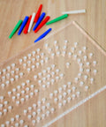 Clear Acrylic Cribbage Board Template Kit With Twelve Colorful Counting Pegs For Game Night Essentials showing pegs and drilled holes.