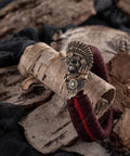 Antique bronze brass paracord buckles with skeleton design on braided EDC bracelet, 4.2x2.4 cm, rustic background