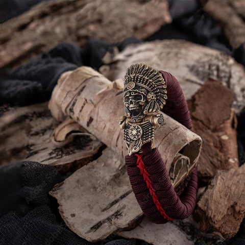 Antique bronze brass paracord buckles with skeleton design on braided EDC bracelet, 4.2x2.4 cm, rustic background