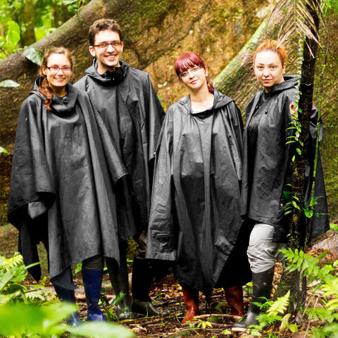 Group wearing 10 Pack Adult Rain Ponchos With Drawstring Hood Waterproof Thickened Rain Coats For Men And Women in forest.