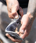 Close-up of Heavy Duty Indexing Crowbar And Nail Puller Wrecker Tool in hand, showing steel claw for demolition tasks.