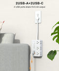 Game Changing Desktop Surge Protector Power Strip With Six AC Outlets And Four USB Charging Ports Low Profile Extension Cord on wall next to couch.