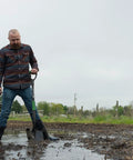 Man using Short-Handle Digging Shovel With Heavy Duty Carbon Steel Build, Ergonomic No-Slip H-Grip, D Handle outdoors on wet soil.