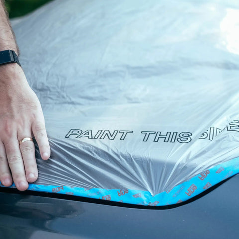 Hand applying Clear Plastic Sheeting 10 Micron 20x250 Ft Protective Masking Film For Automotive Painting And More on car