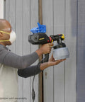 Person using iSpray Front End Nozzle For HVLP Sprayers Broad Interior And Exterior Coverage spraying a wooden wall