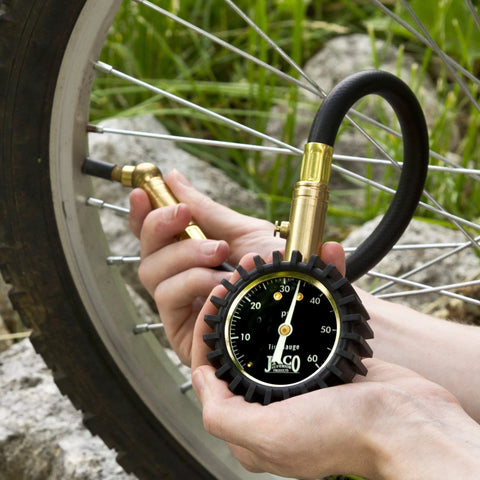 JACO ElitePro tire pressure gauge with brass connector attached to a bicycle tire valve, black dial up to 60 PSI