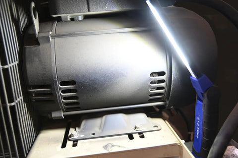 Slick Foldable DoubleSided LED Light With Wireless Charging 1500 Lumens Magnetic 20Lb Base illuminating a machine.