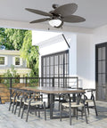 Inland Breeze Tropical 52 Inch Indoor Outdoor Ceiling Fan With Light, Five Blades, Reversible Motor over a patio table.