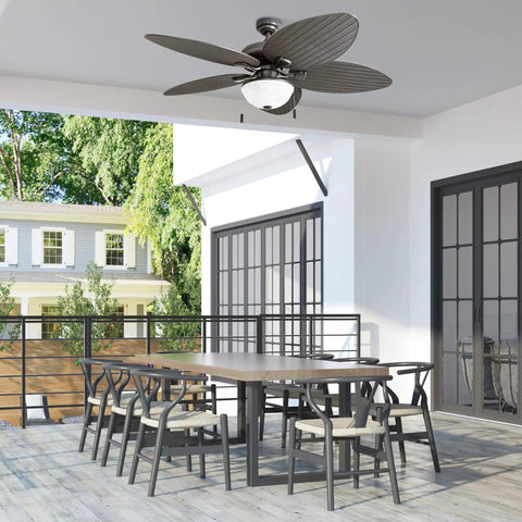 Inland Breeze Tropical 52 Inch Indoor Outdoor Ceiling Fan With Light, Five Blades, Reversible Motor over a patio table.