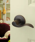 Heritage Lever Passage Set in Aged Oil Rubbed Bronze, installed on an interior door, view from side angle.