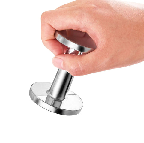 Hand holding Pro Grade 2 Inch Espresso Tamper For Baristas Durable Stainless Steel Build Delivers Even Heat For Consistent Temperature.