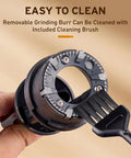 Inside view of Ollygrin Flat Burr Coffee Grinder With Adjustable Grind Settings For Espresso French Press Capsule, showing removable burr and cleaning brush.