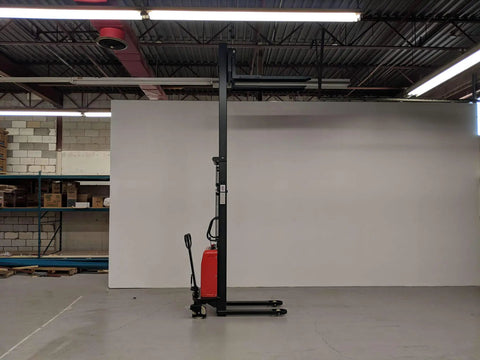 Heavy Duty Thin Leg Semi Electric Pallet Stacker 2204 Lbs Capacity 138 Inch Lift Height 110V Plug displayed in warehouse.