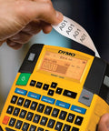 Close-up of hand using label maker with Rhino Industrial Flexible Nylon Labels Three Quarters Inch By Eleven Point Five Foot Black Print On White Tape