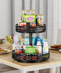 Two-tier black metal Lazy Susan turntable, 12-inch diameter, on kitchen counter; holds cans, boxes, and bottles.