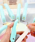 Person using One-Handed 2mm Circle Pattern Embosser With Built-In Waste Storage, Easy-Squeeze Punch Tool in sky blue on paper crafts.