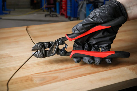 8 Inch Mini Bolt Cutter With Chrome Moly Steel Construction And Induction Hardened Blades cutting wire on a wooden table