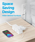 Flat Plug Power Strip With Five Foot Extension Cord Giving Six Wide Spaced AC Outlets Plus Three USB Charging Ports Including One Fast Type C, compact design hidden behind furniture charging a phone.