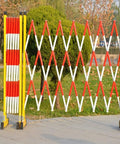 Built Like A Tank Retractable Traffic Barricade Featuring Smooth Glide Pulleys And A Quick Fold Stand For Snatch And Go Crowd Control Fencing Construction Sites in a park.