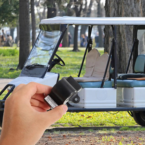 Hand holding Inductive Throttle Sensor Assembly in front of a parked golf cart, showing size and compatibility with most systems.