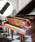 Six Pack Continuous And Piano Hinges For 4 Inch Openings In Black 304 Stainless Steel, shown near a grand piano.