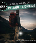 Hiker holding Hybrid Solar Lantern Go To Camping Buddy With USB Or AA Battery Power as dusk falls over mountain landscape.