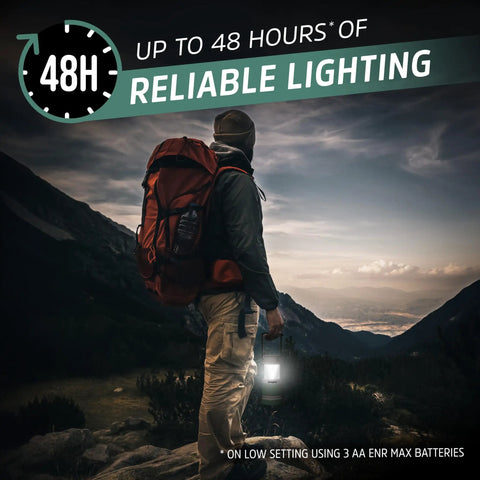 Hiker holding Hybrid Solar Lantern Go To Camping Buddy With USB Or AA Battery Power as dusk falls over mountain landscape.