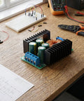 Professional Top Shelf 300 Watt Adjustable Dc Dc Buck Converter Module on a workbench, featuring capacitors and connectors.
