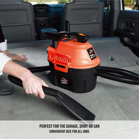 Compact 2.5 Gallon Wet Dry Shop Vacuum With 2 Peak HP Blower Function in use on car seat with crevice tool and hose