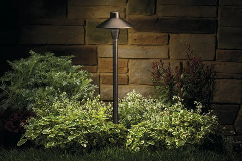 1 Light Outdoor Path Light in Centennial Brass Finish for Pathway Garden and Yard Illumination among garden greenery at night