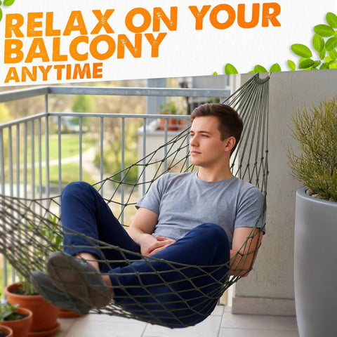 Man relaxing in dark green mesh hammock on balcony; Chill Out Mesh Hammock Between Two Trees No Stand Needed Outdoor Camping Lightweight 13 Oz Nylon Net Bed Breathable 220 Lb Capacity for Backyard Garden Patio Beach Travel Dark Green.