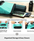 Waterproof Dry Backpack With Phone Case Large Floating Dry Bag For Kayaking Travel Hiking Fishing Camping And Beach Gear 5L To 55L Heavy Duty Roll Top Teal on sand with storage items visible