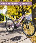 26 Inch Mountain Bike For Adults And Teens With Steel Frame And Suspension Fork, 21 Speed V Brakes, Purple, parked on trail.