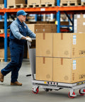 Side view of CAMMOO hydraulic lift table cart, gray frame with red wheels, carrying four large cardboard boxes.