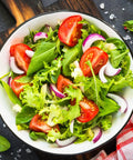 Bowl of fresh garden salad with mixed greens, tomatoes, onions, showing use for Over 20,000 Lettuce Seeds Pack With 10 Fresh Varieties
