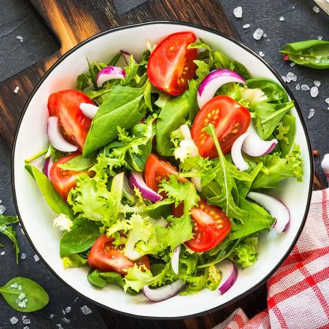 Bowl of fresh garden salad with mixed greens, tomatoes, onions, showing use for Over 20,000 Lettuce Seeds Pack With 10 Fresh Varieties
