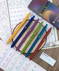 Six Pack Gel Ink Pens With 0.5mm Fine Point, Smooth Flow For Journaling And Note Taking, Color Coded Set on wooden table