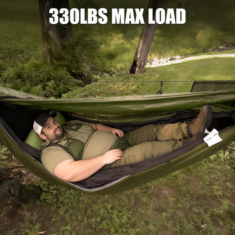 Person relaxing in 4 In 1 Camping Hammock Tent With Rain Fly And Mosquito Net For Adults, set in a green outdoor environment.