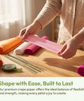 No Fuss Crepe Paper Flower DIY Kit With Stem Wire Tape And Glue Sticks For Easy Peasy Paper Flower Creations Classroom Crafts And Beautiful Floral Bouquets For Beginners, hands holding pink crepe paper strip with wire and tape rolls